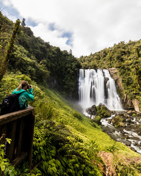 Traveler taking a picture of Marokopa Falls in New Zealand