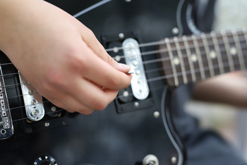 Fototapeta premium playing a guitar, musician playing guitar close-up on hand