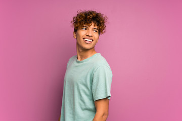 Young african american man over isolated purple wall laughing