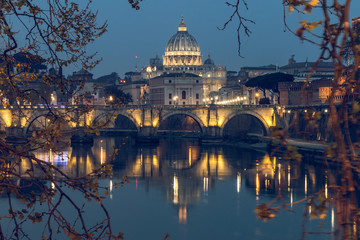 Fototapeta premium Aurelius Bridge or Ponte Sisto Bridge with St Peters Basilica and Tiber River at the blue hour with artificial lighting and reflections. Stone bridge at night over river Tiber in the historic center o