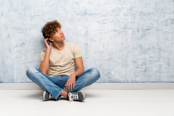 Young african american man sitting on the floor thinking an idea