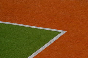 Artificial green and brown turf texture background with white line marks