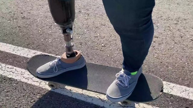 Disabled man skater training with leg prosthesis. Paralympic Sport Concept