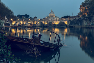 River Tiber in Rome and St Peters Cathedral at night. In the foreground a sunken ship at the pier....