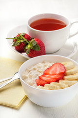 Bowl of breakfast muesli decorated with banana, strawberry slices and chia seed