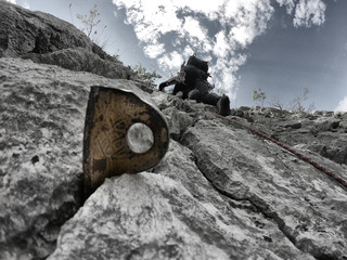 Piton in the rock crack. One man climbing.