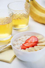 Bowl of breakfast muesli decorated with banana, strawberry slices and chia seed