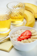 Bowl of breakfast muesli decorated with banana, strawberry slices and chia seed