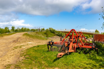 Fototapeta premium old rusty abandoned cultivator in the fields