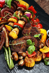 Assorted delicious grilled meat and skewer with vegetable on rustic table