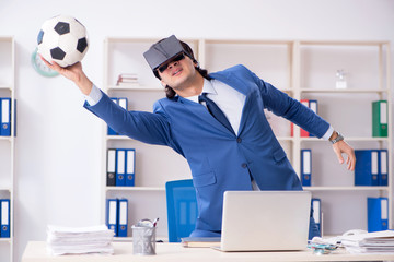 Young handsome businessman playing soccer with virtual glasses 