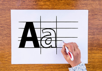 Typography. woman hand draws letters, font on paper sheet