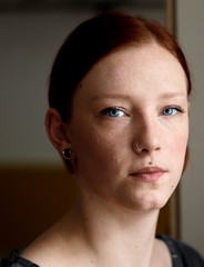 young pretty ginger girl with blue eyes looking sorrowful out of the window