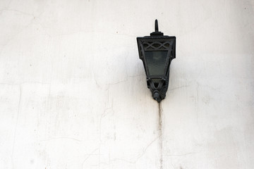 forged black street lamp on a white wall
