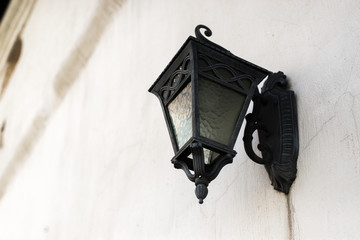 forged black street lamp on a white wall