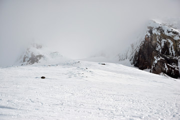 Fototapeta premium Snow covered terrain on Mount Hood, a volcano in the Cascade Mountains in Oregon popular for hiking, climbing, snowboarding and skiing, despite risks of avalanche, crevasses and weather on the peak.