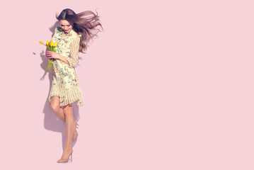 Beauty glamour girl with spring tulip flowers. Beautiful young woman posing with bouquet of tulips....