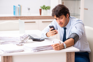Man under stress measuring his blood pressure