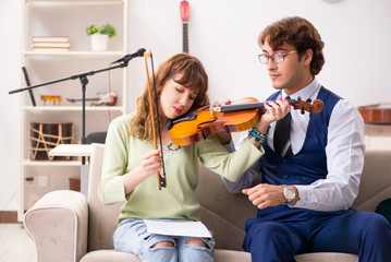 Young woman during music lesson with male teacher