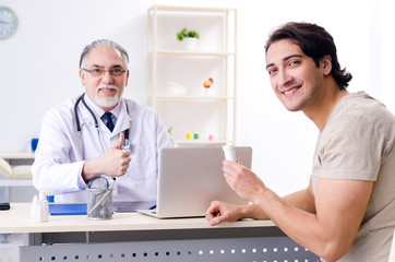 Young man visiting old male doctor 