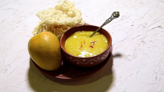 Aam Ras or Alphonso mango pulp with kurdai which is a fried dish made using wheat/gehu. selective focus