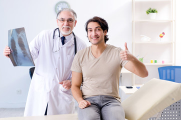 Obraz premium Young man visiting old male doctor radiologist 