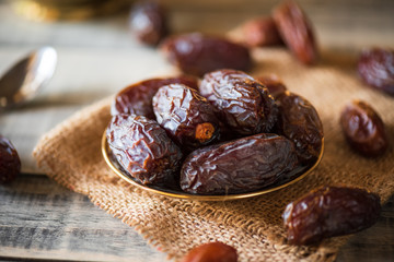 Ramadan food and drinks concept. Dates fruit in a bowl on wooden table background.