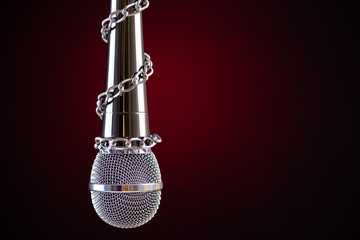 Microphone with a chain, depicting the idea of freedom of the press or freedom of expression on...