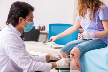 Obraz premium Leg injured young woman visiting male doctor 