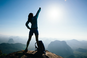 Successful woman hiker in the sunrise mountain top