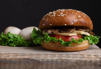 crispy vegetarian burgers with mushrooms and marzipan cheese, tomato and salad leaves,baked bun with sesame 