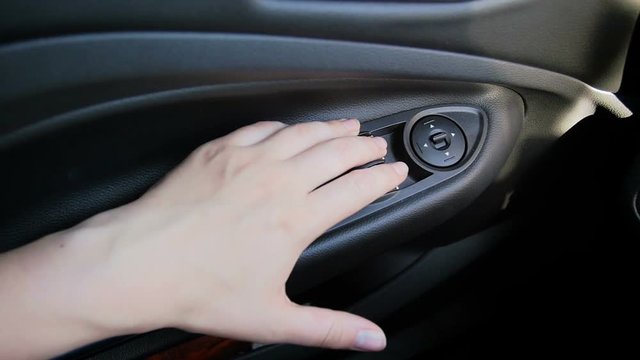 Closeup slow motion video of female hand pressing windows control knobs on dashboard