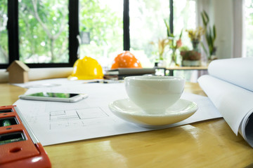 coffee cup and architectural blueprints on working table