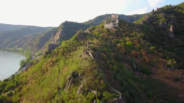 Aerial circling and fly over view of medieval Durnstein castle ruin and town in Wachau valley Lower Austria along the river Danube