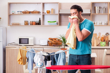 Young man husband doing clothing ironing at home 