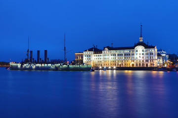 Obraz premium Russian cruiser Aurora in the mouth of Neva river in Petersburg on the background of Nakhimov Naval School in the evening. The navy museum and the symbol of Great October revolution and Petersburg