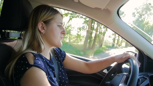 Slow motion video of young woman reversing while driving a car and parking