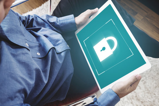 Mobile device security system. a man using digital tablet and lock icon on screen
