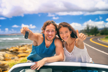 Road trip travel couple showing car keys on summer vacation. Happy young people adventure lifestyle. Carsharing, rideshare, autostop car young adults buying new car, rental insurance young people.