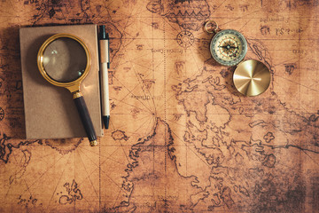 Navigation Travel Explore Journey and Destination Vacation Planning ,Exploration The World for Holiday Trip Concept. Layout of Notebook, Magnifying Glass and Navigator Compass on Global Map Background