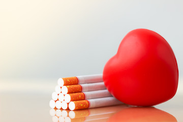 Red heart and cigarettes. Smoking cigarette destroying health. heart disease.