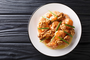 Crispy shrimp tossed in a creamy sweet sauce and candied walnuts close-up. horizontal top view