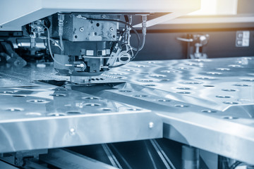 The hi-speed CNC punching machine in light blue scene. Modern metalworking manufacturing process by punching machine.