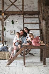 Beautiful family with two sons in room on stairs