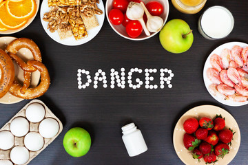 Set of allergy food with antihistamine pills on wooden table