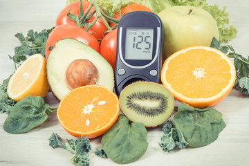 Glucometer for measuring sugar level and ripe fruits with vegetables as healthy nutritious snack containing vitamins