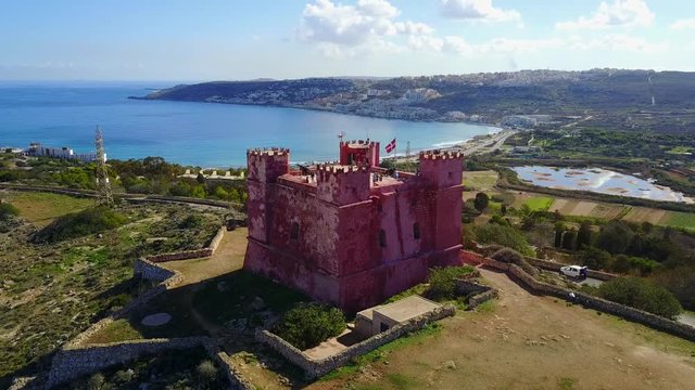 Aerial view of Red Tower former military watch post in Malta near Mellieha across from Gozo Island surrounded by crystal clear blue water on a sunny summer morning geometric shapes