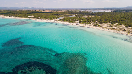 Fototapeta na wymiar Amazing drone aerial landscape of the charming beach Es Trencs and the boats with a turquoise sea. It has earned the reputation of Caribbean beach of Mallorca. Spain