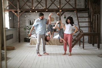 Dad and mom hold children by foots upside down