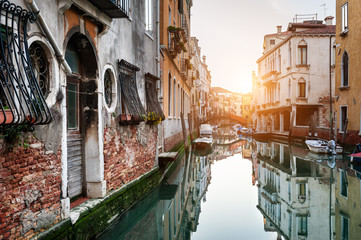 Scenic canal with old architecture at sunset in Venice, Italy.